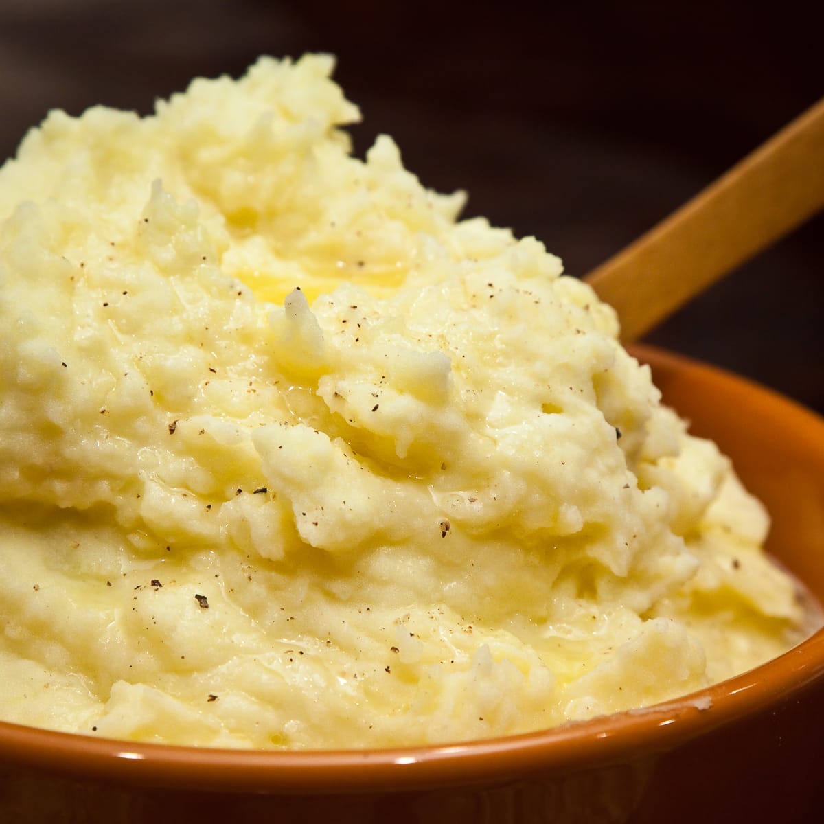 A bowl of fluffy mashed potatoes with butter. 