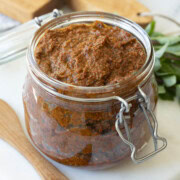 Glass jar of pesto rosso, red pesto, ready to enjoy.