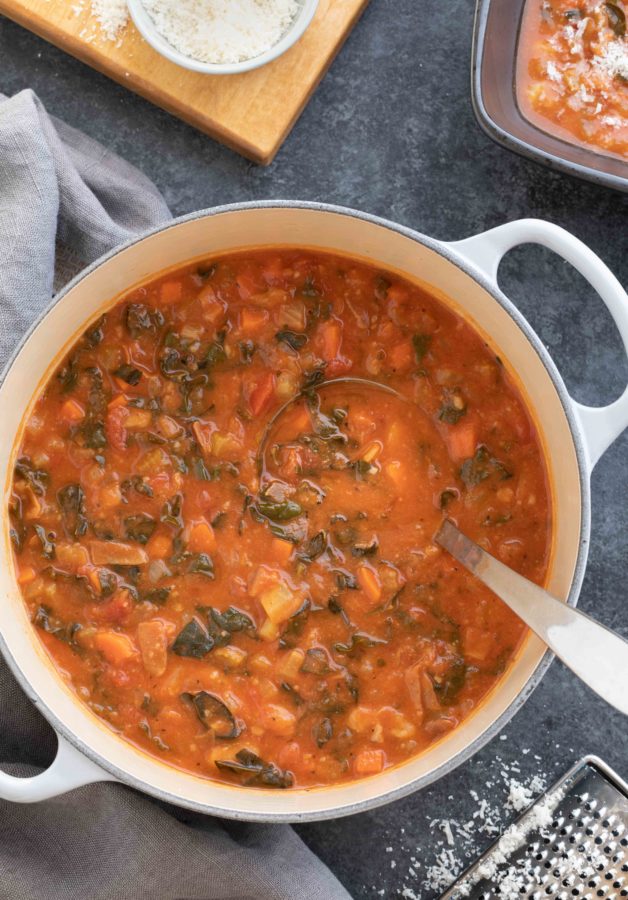 A pot of ribollita soup ready to serve with a ladle in the pot.