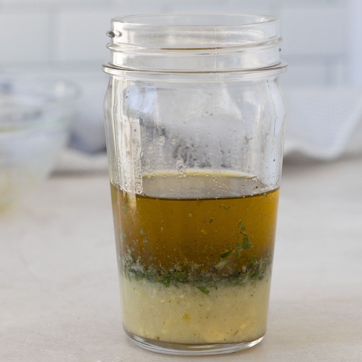 Lemon vinaigrette ingredients in a jar, not blended. 