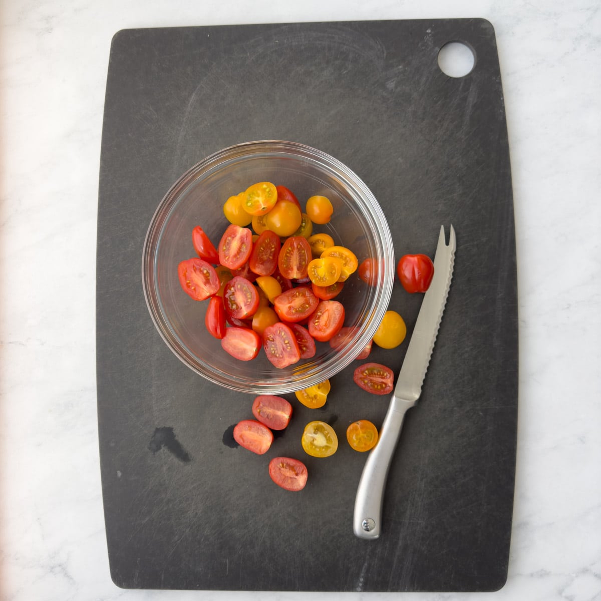 Slicing cherry tomatoes in half for a salad. 