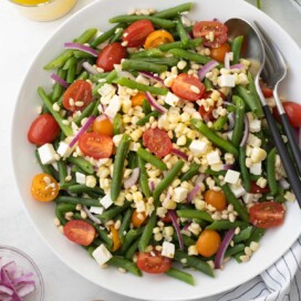 Summery cold green bean salad with cherry tomatoes, corn kernel, and feta cheese with vinaigrette.