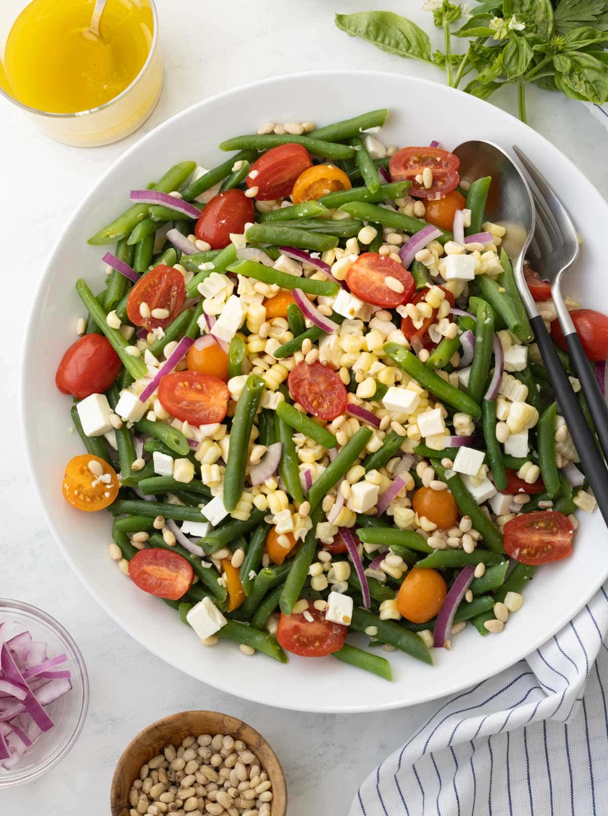 Summery cold green bean salad with cherry tomatoes, corn kernel, and feta cheese with vinaigrette.

