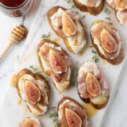 Goat cheese crostini with figs and prosciutto drizzled with honey.