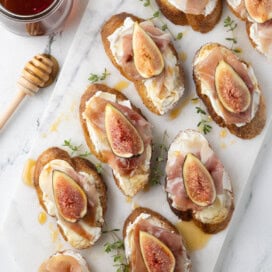 Goat cheese crostini with figs and prosciutto drizzled with honey.