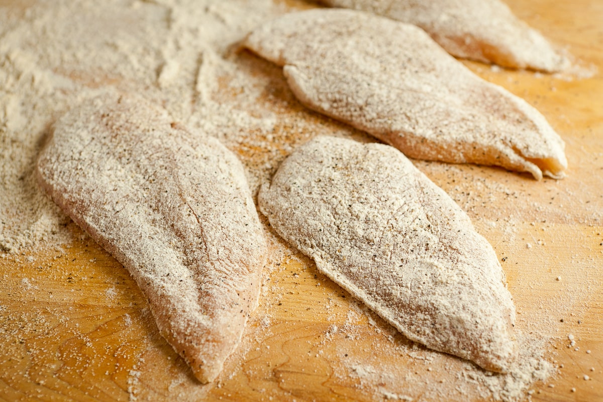 Chicken cutlets dusted with flour.