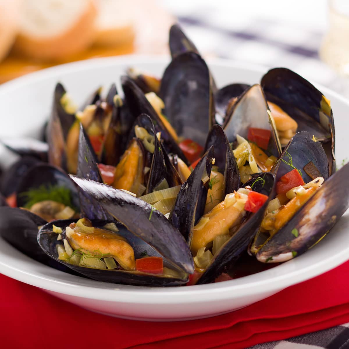Steamed mussels in a white bowl. 