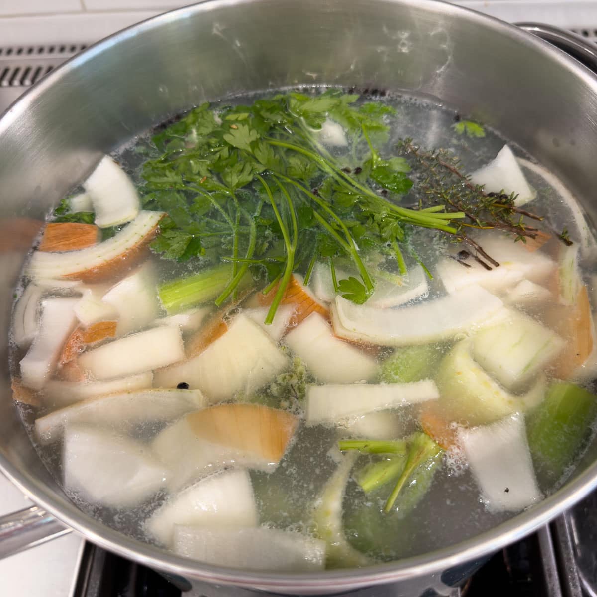 Add chicken with most skin removed, along with vegetables, herbs, vinegar, and peppercorns to pot.