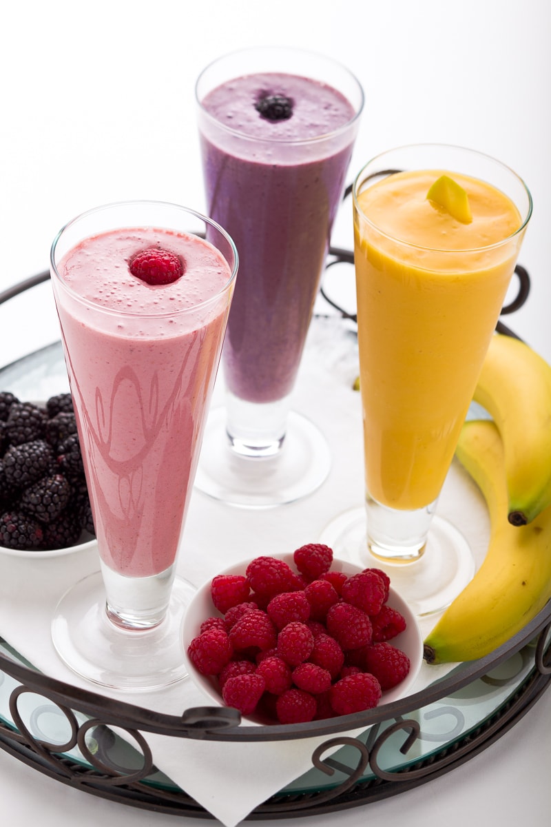 Three healthy smoothies in tall glasses.