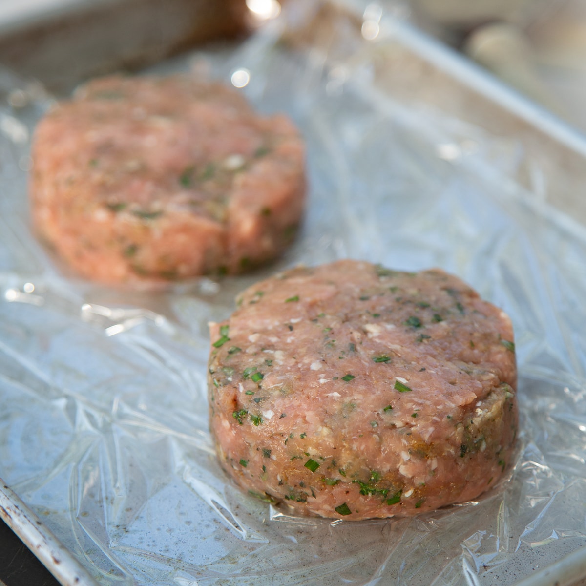 raw turkey burgers going on the grill.