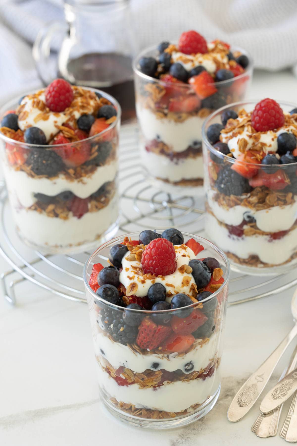 Colorful Greek yogurt parfaits in glasses with layers of granola, yogurt, and berries. 