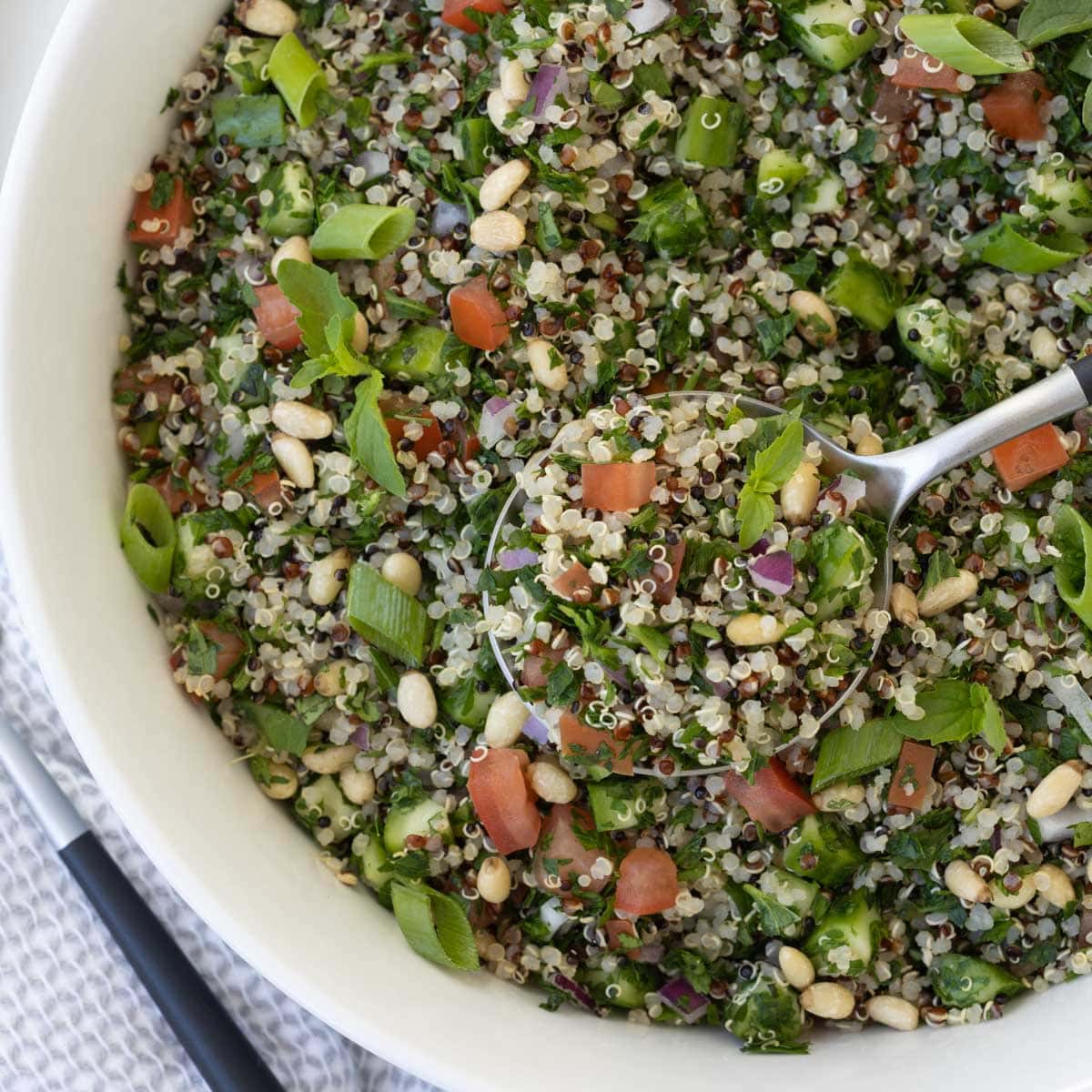 A close up of tabouli salad in a white bowl.

