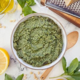 A bowl of bright green Genovese pesto, classic Italian basil pesto.