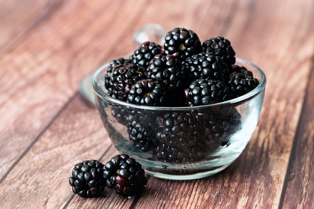 Glass bowl of fresh blackberries.