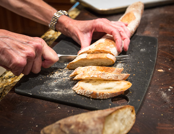 Slicing baguette on a diagonal for crostini.