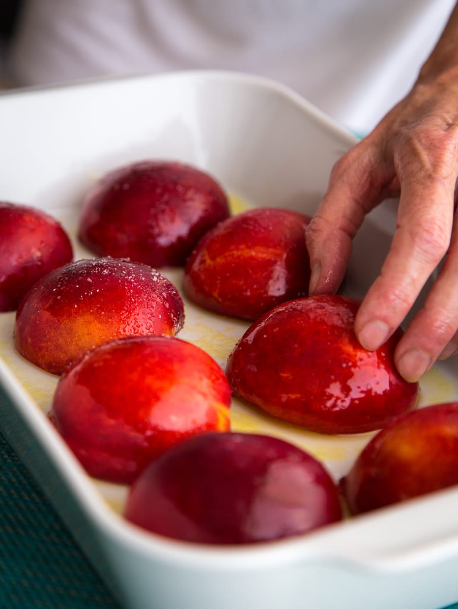Roasting nectarines in a white casserole dish.