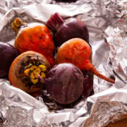 Colorful red and golden roasted beets in aluminum foil.