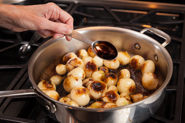 Adding Balsamic to the pan of pearl onions. 