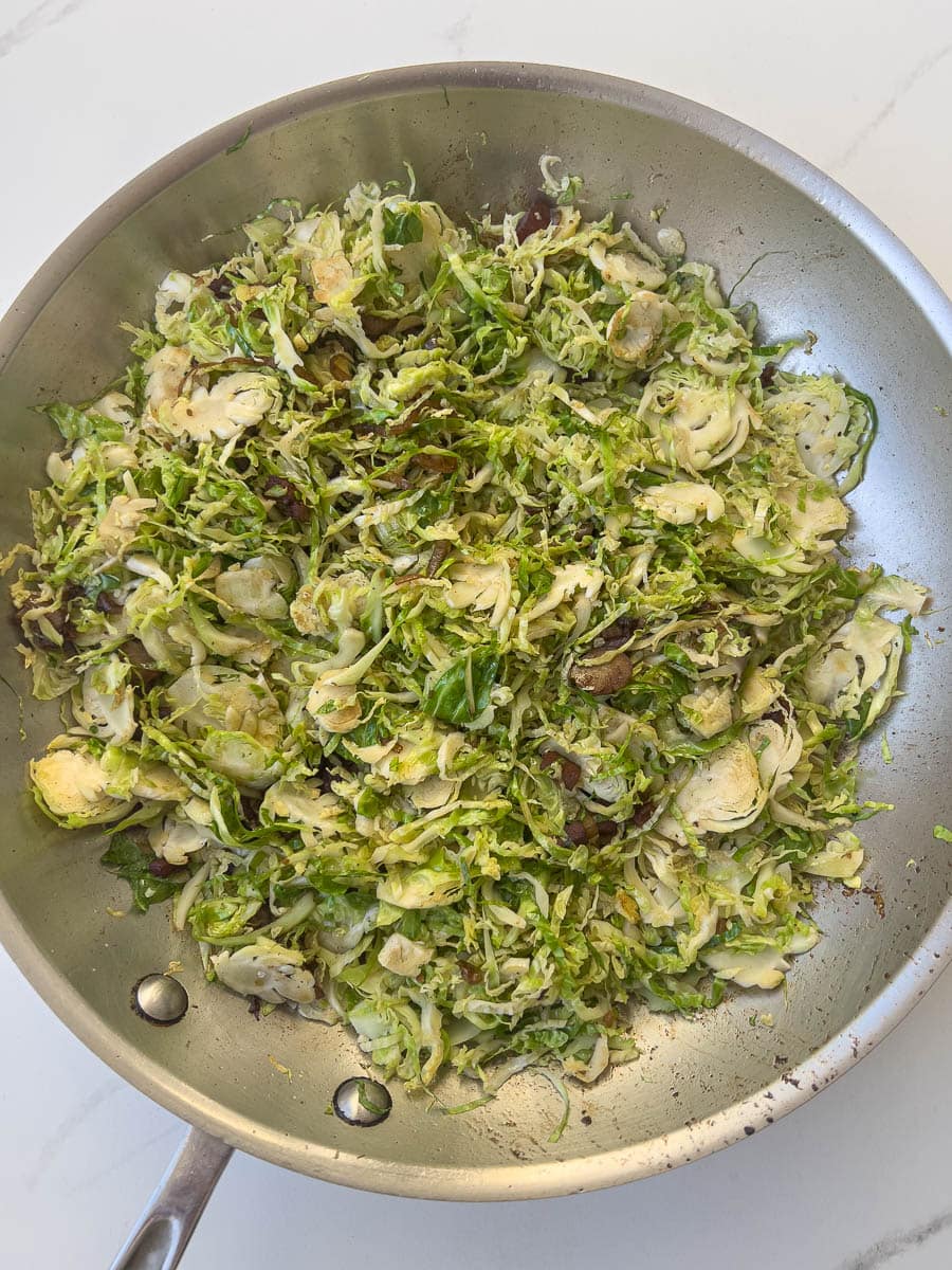 Cooked shaved brussels sprouts in a saute pan