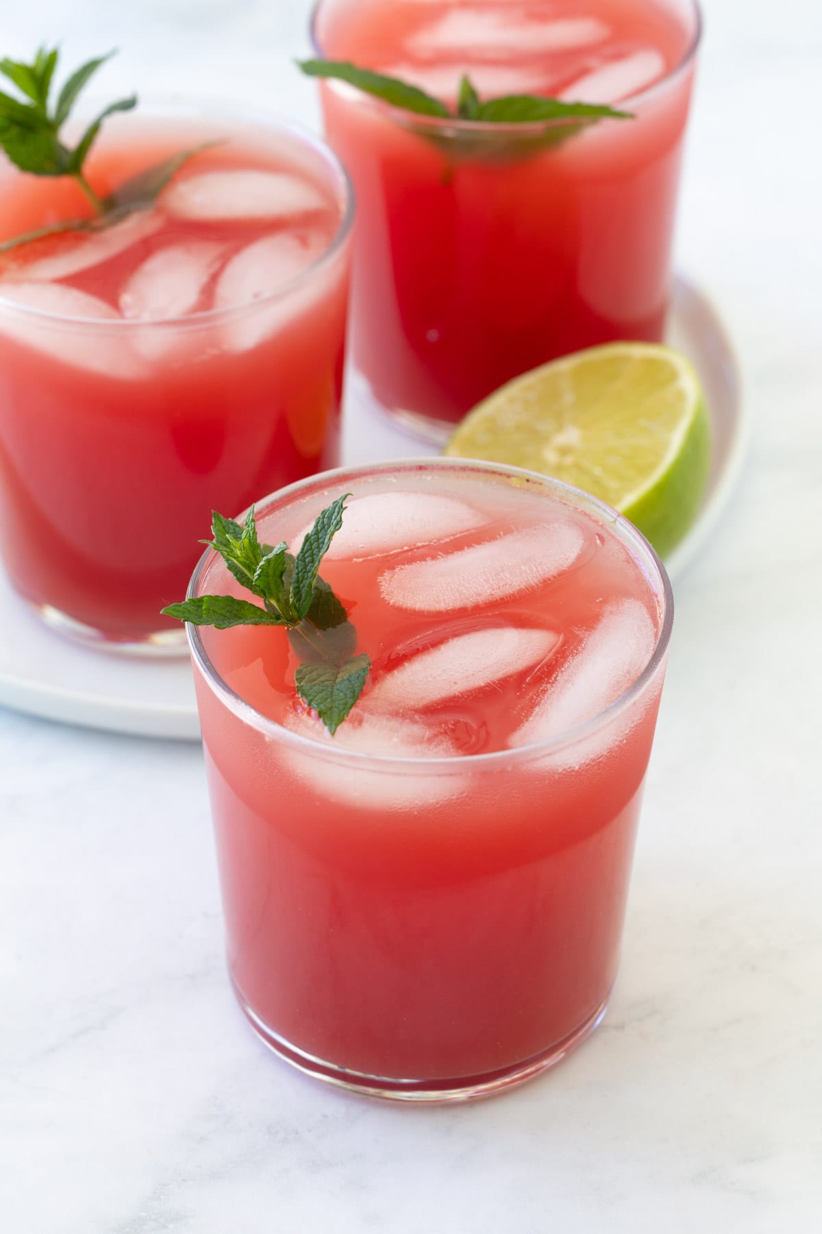 Beautiful bright red watermelon water with mint and lime in a clear glass. 