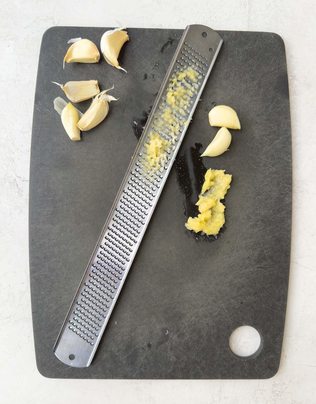 Using a microplane zester tool for fine garlic that melts into a recipe.