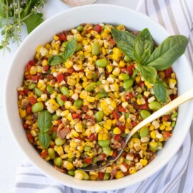 Closeup of corn succotash with red and green peppers and bacon.