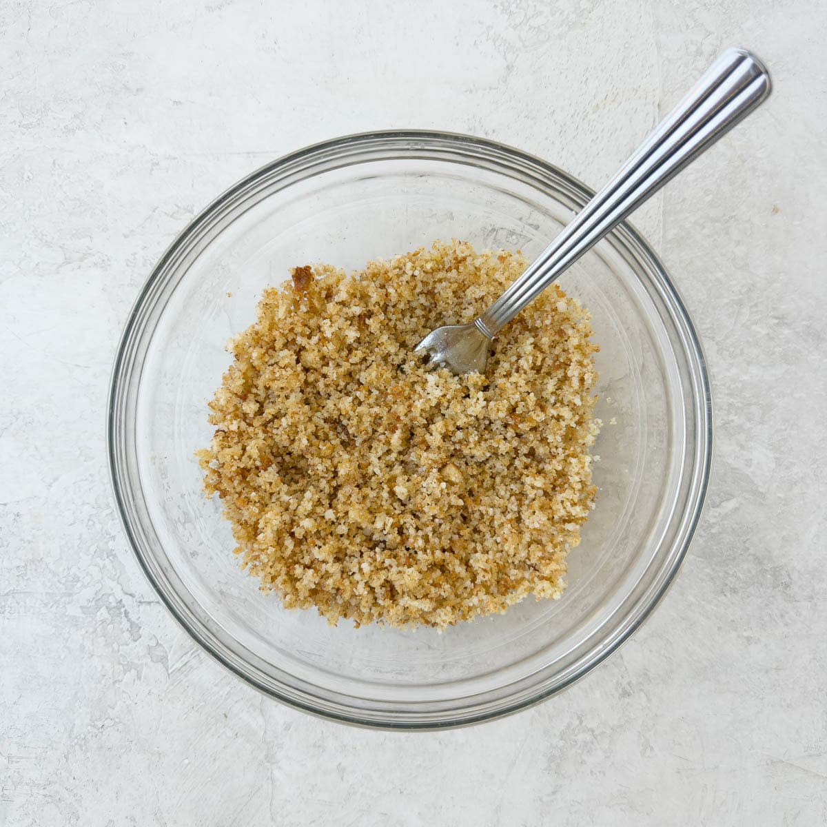 Breadcrumb topping with parmesan cheese and olive oil in a small bowl.