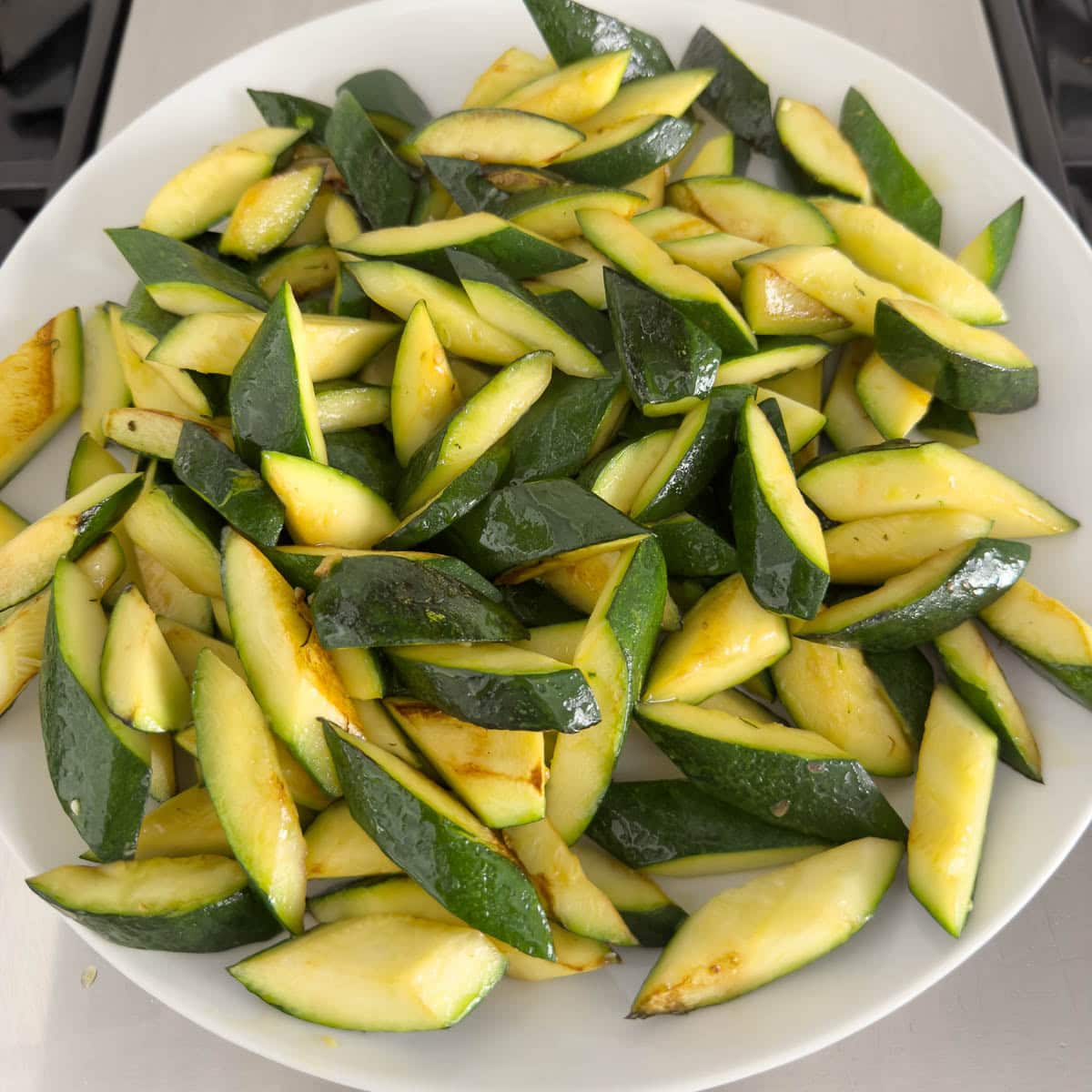 Sauted zucchini on a plate waiting for the next step.