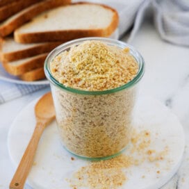 A tall jar with golden crunchy breadcrumbs piled high and overflowing.