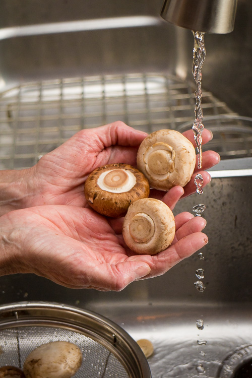 Rinsing mushrooms in sink.