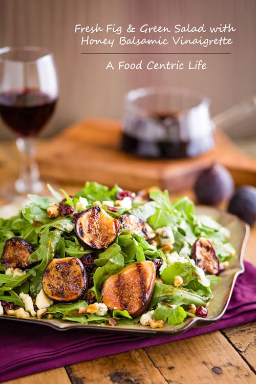 A plate of salad greens with grilled figs, cheese, and nuts. 