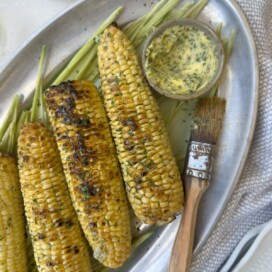 Closeup of grilled corn on the cob with herb butter.