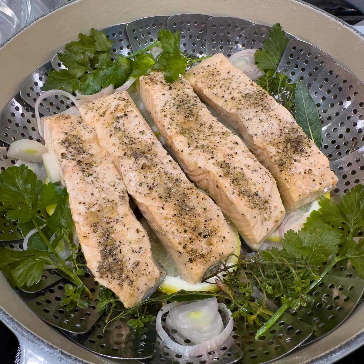 Pale peachy colored salmon filets after steaming in the steamer basket. 