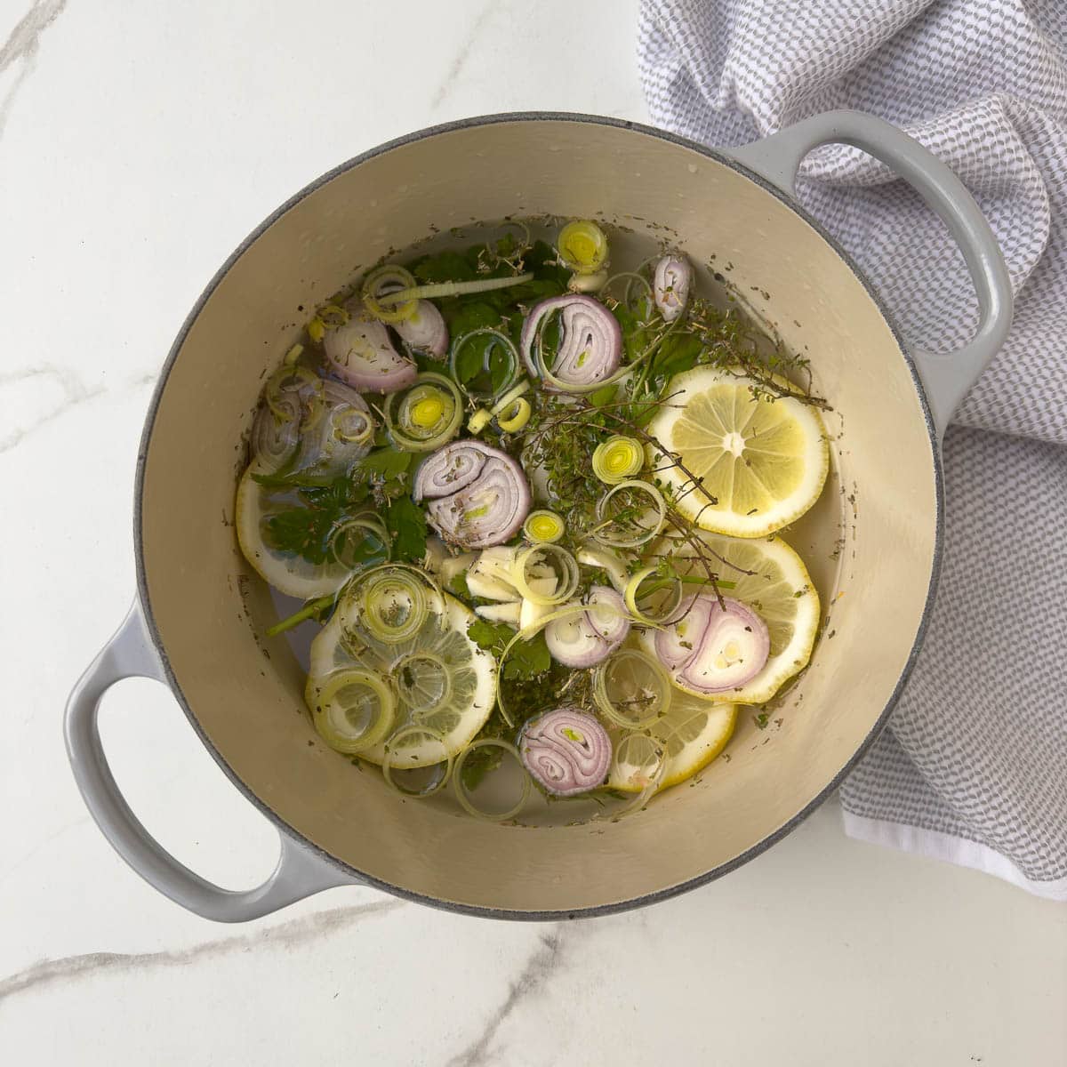 The aromatic steaming liquid to steam salmon with herbs, lemon, and shallots. 