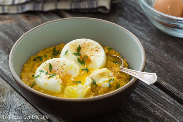 A single bowl of polenta with poached eggs on top. 