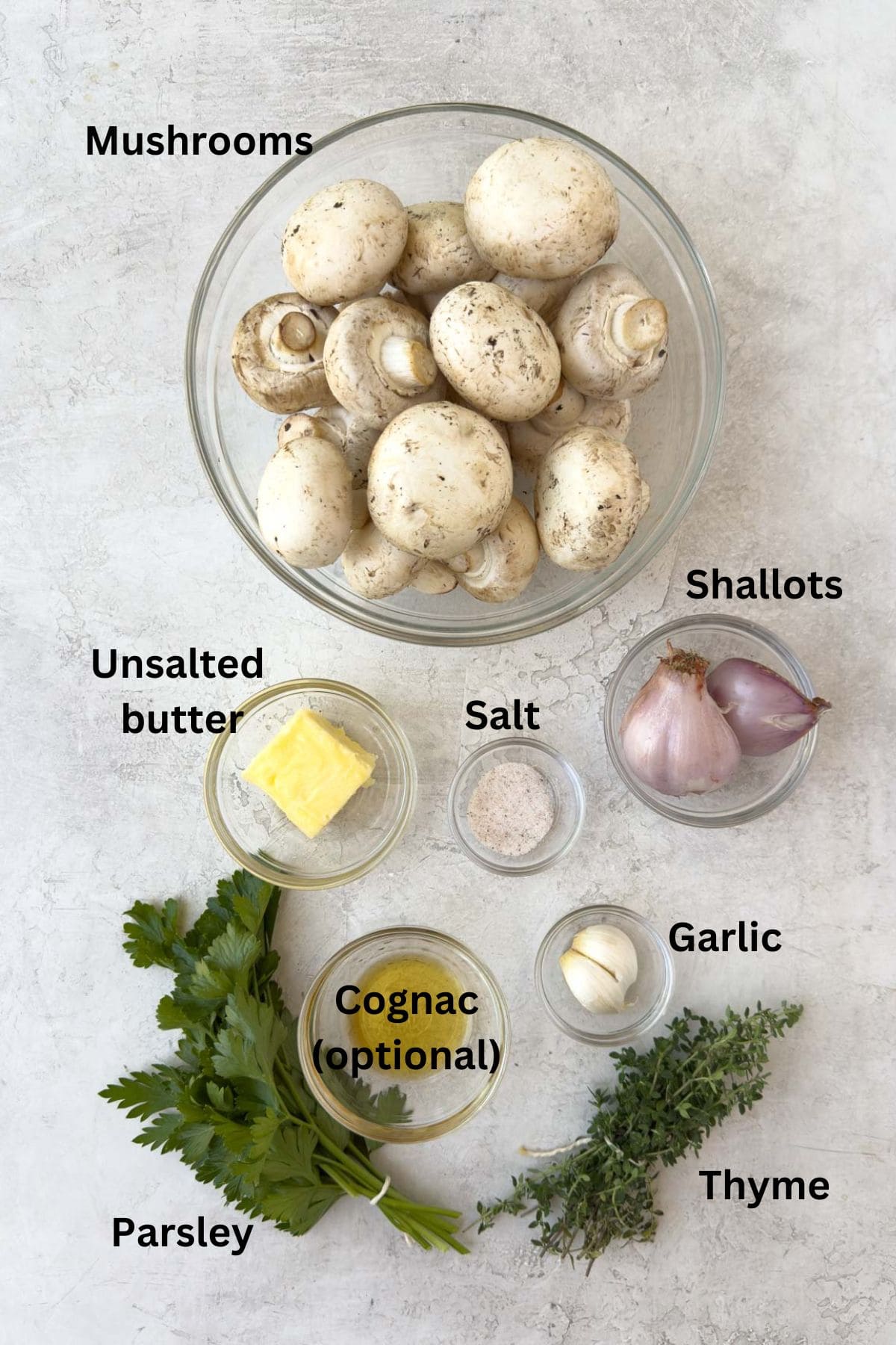 Ingredients for mushroom duxelles on gray counter. 