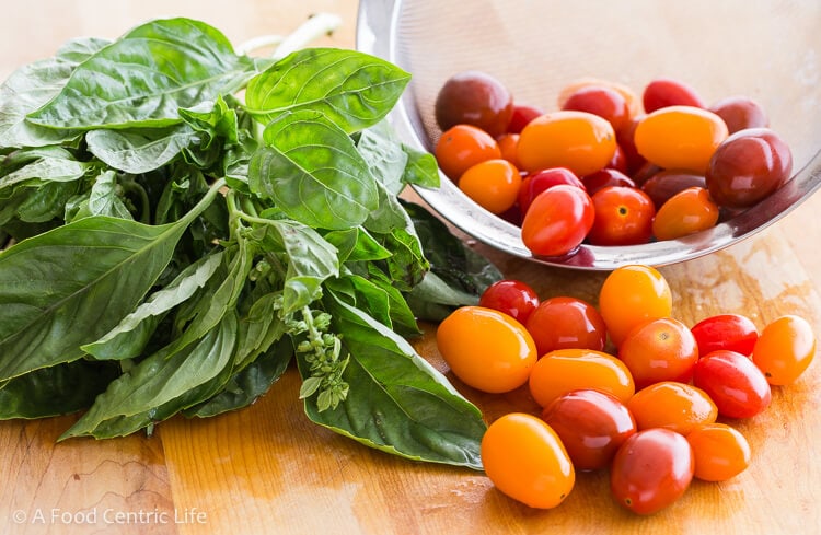 Basil leaves and tomatoes for Caprese skewers.
