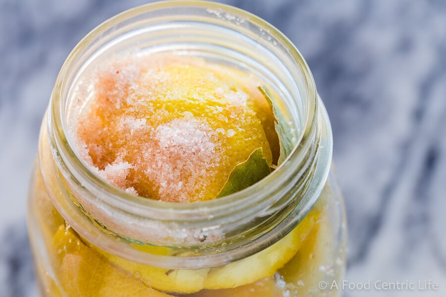 Close-up of a jar of preserved lemons with salt.