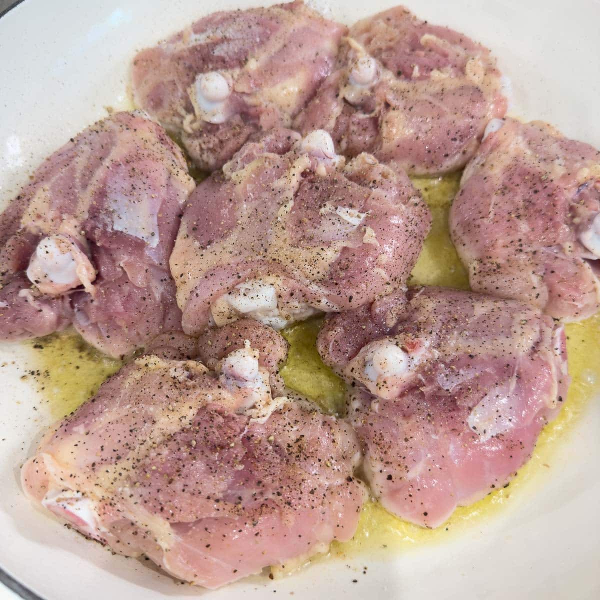 Browning chicken thighs in olive oil skin side down.
