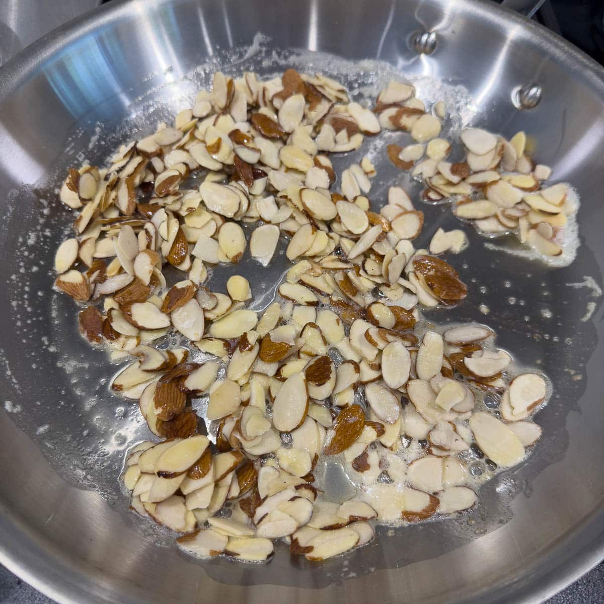 Starting to toast almonds in butter on the stove top.