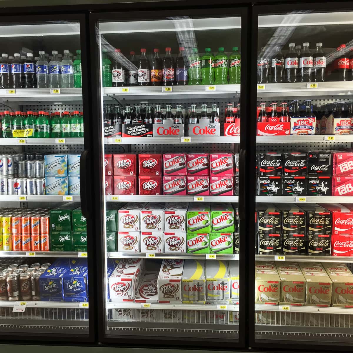 a store refrigerated case filled with soda.
