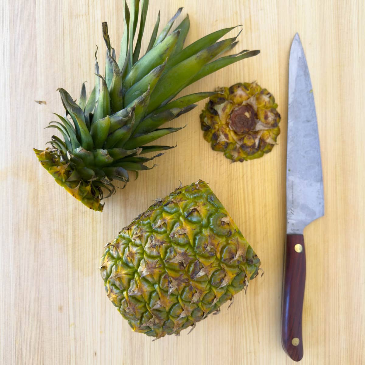 Cutting up a pineapple on a cutting board.