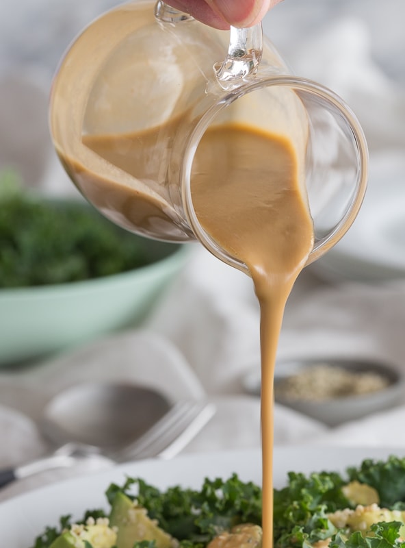 creamy tahini dressing pouring onto salad | AFoodCentricLife.com