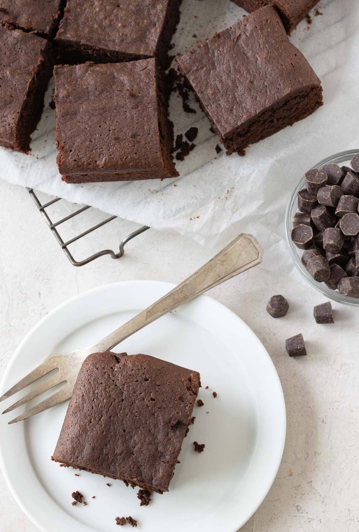 Slice gluten-free brownies on a cooling rack and one on a small plate for serving.