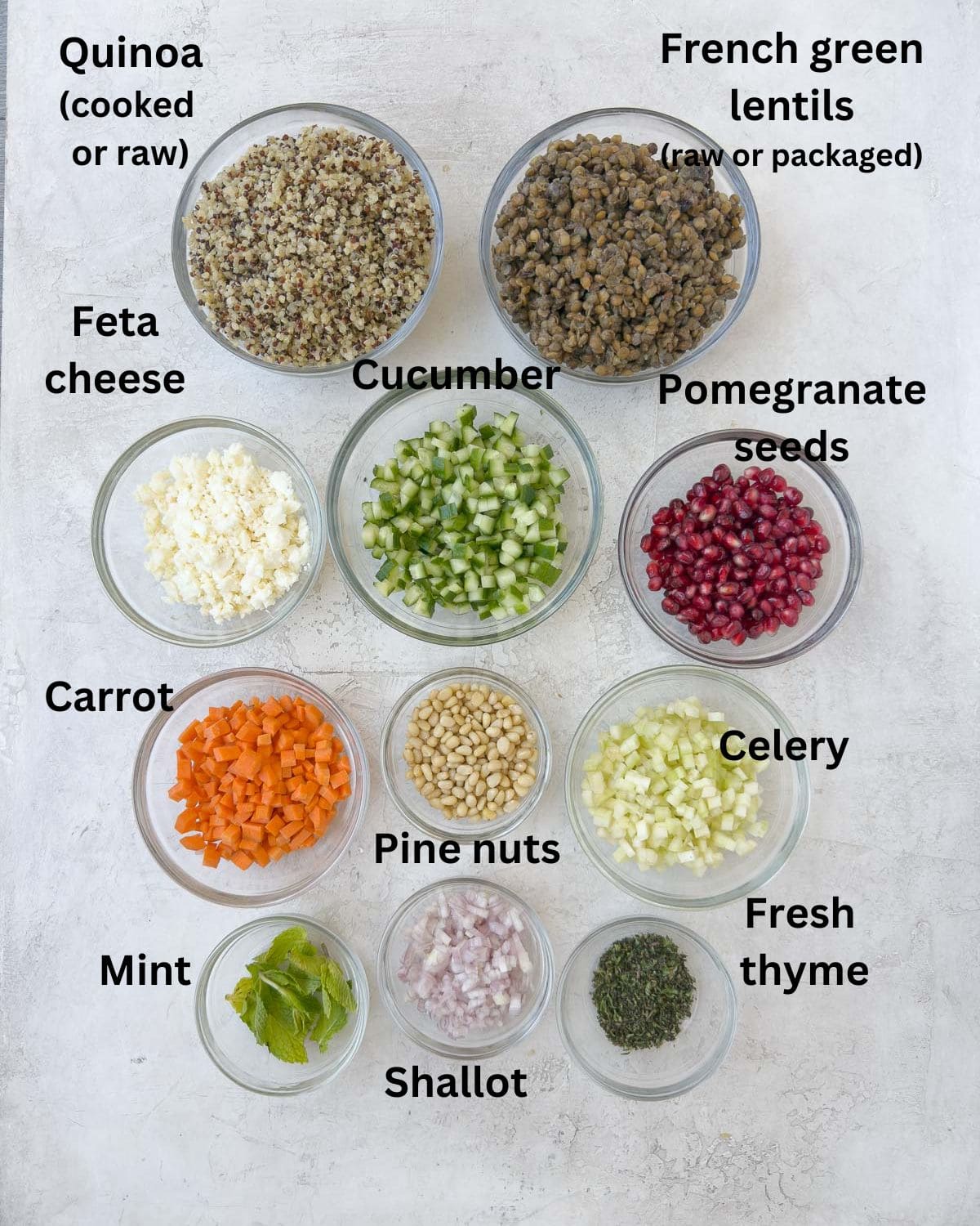 Ingredients for a lentil quinoa salad in prep bowls on a counter ready to go.