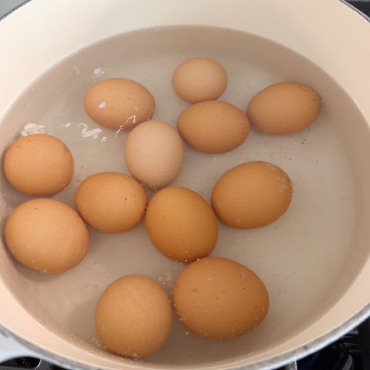 Brown eggs in a pot being hard boiled. 