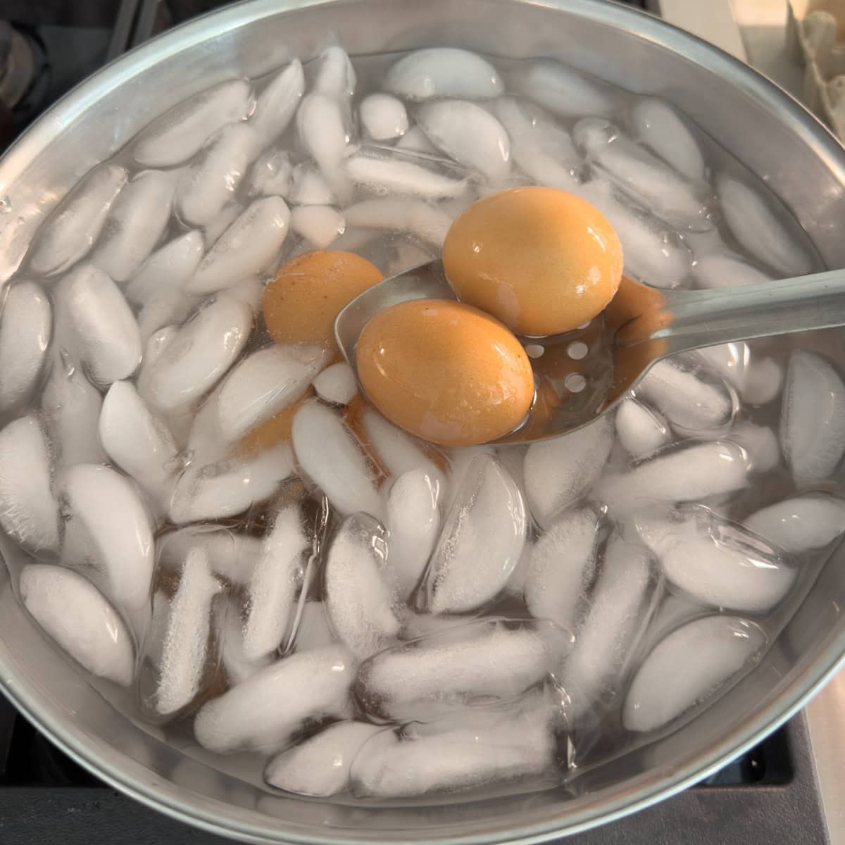 Hard boiled eggs being chilled in an ice bath to cool. 