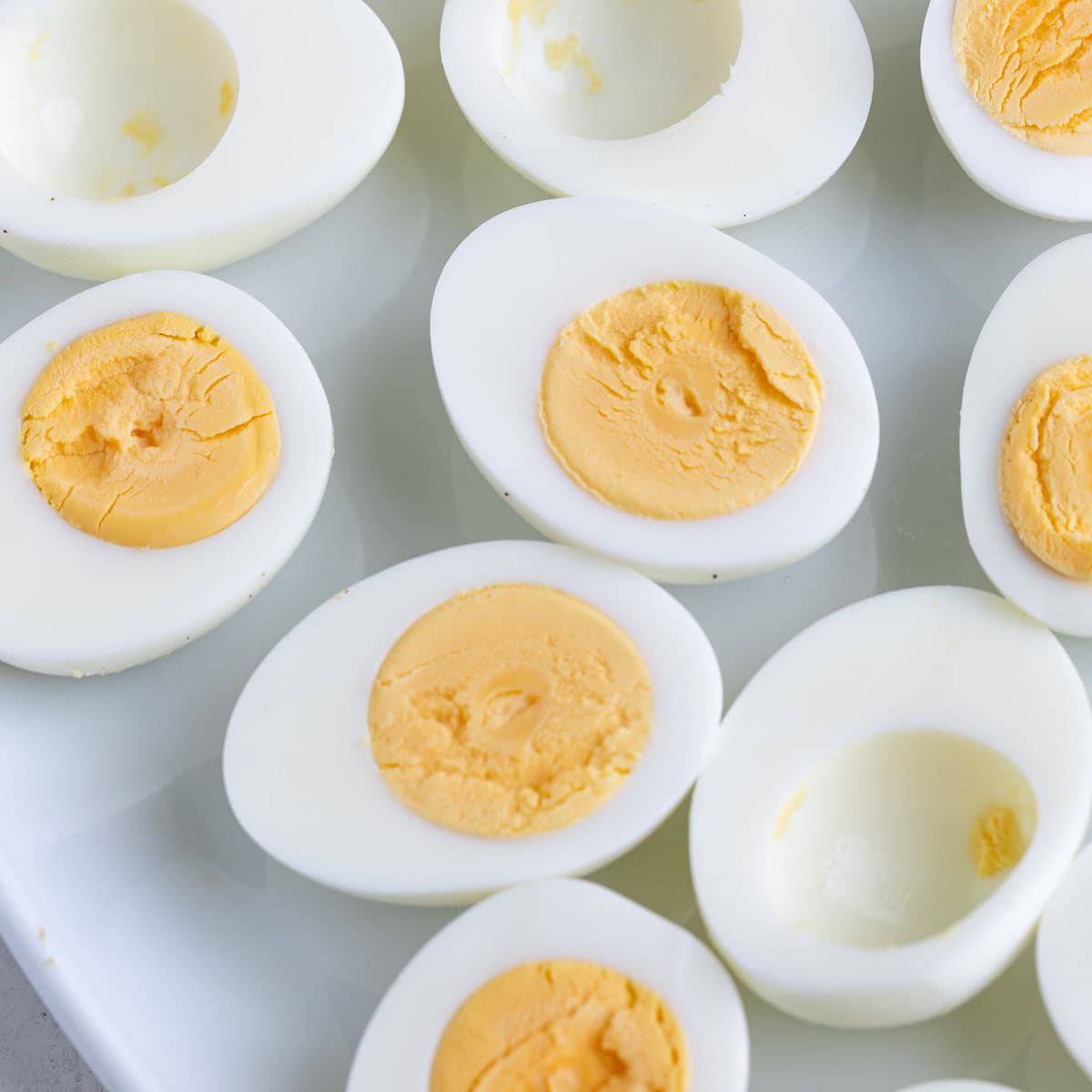 A plate of sliced open hard boiled eggs showing yellow centers.