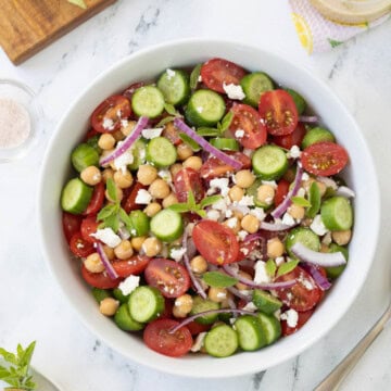 Tomato and cucumber salad, with red onion, feta, and garbanzo beans with greek dressing.