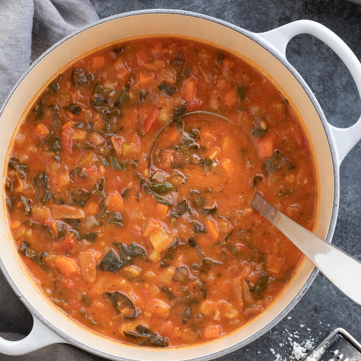 A pot of Italian soup called Ribollita in a gray pot with beans, veggies, and kale. 